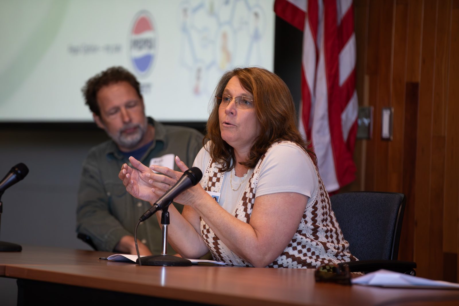 Educator speaking and gesturing at the January AI Summit panel table